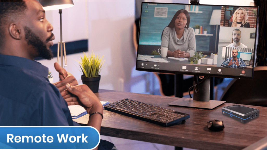 A man sitting at a desk with a laptop and an Azulle Mini PCs, unlocking business potential.