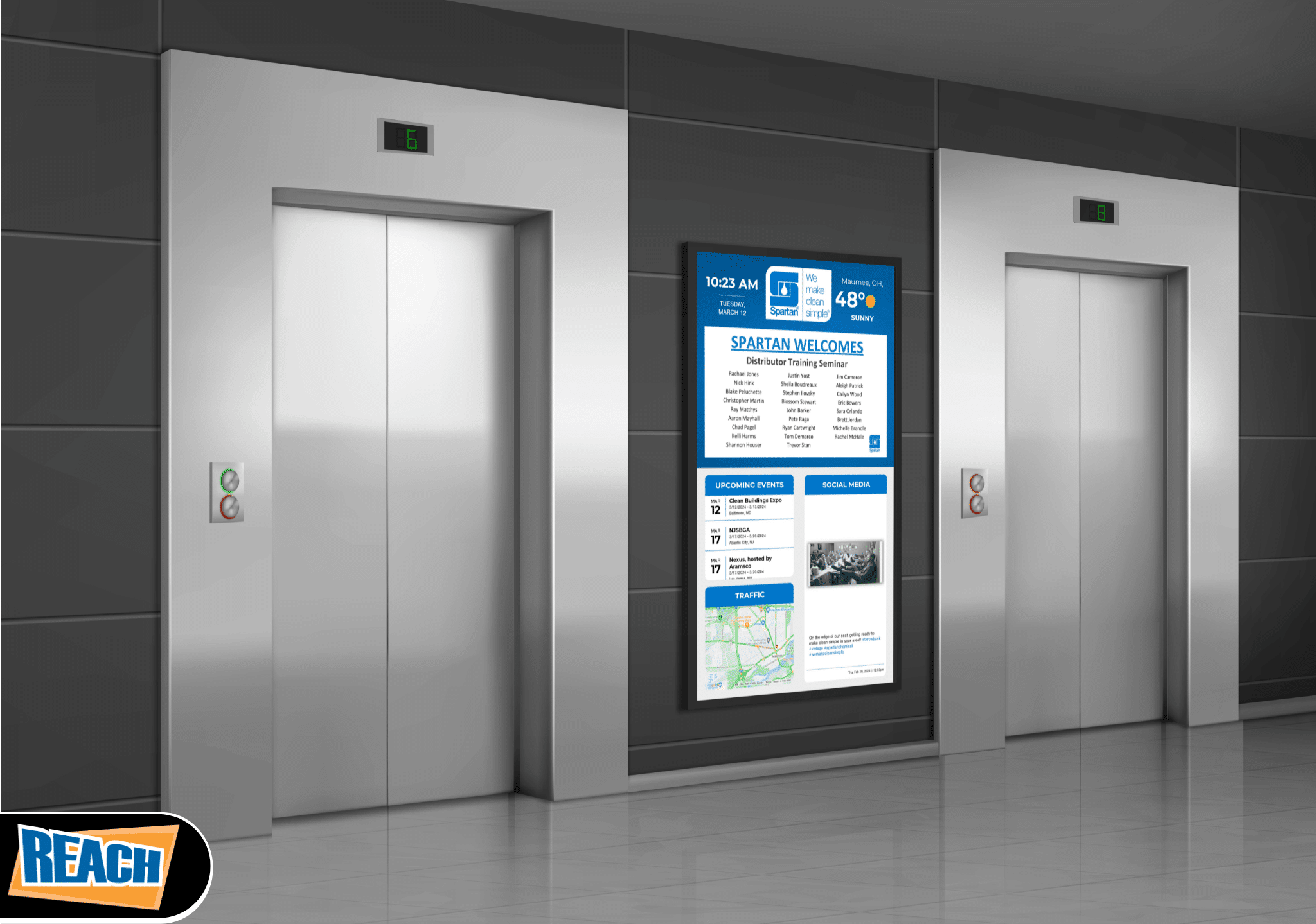 Modern elevator doors next to digital signage in a corporate building lobby.